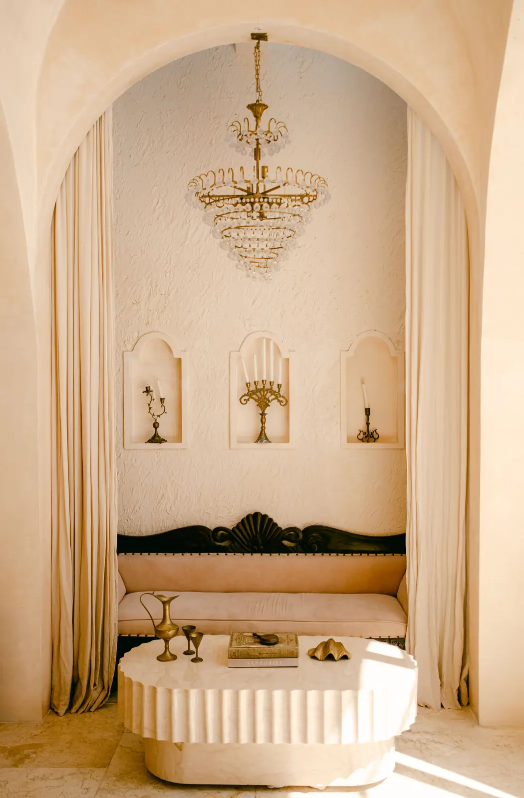 Elegant interior showcasing vintage decor and warm beige tones, featuring a chandelier and ornate furniture.